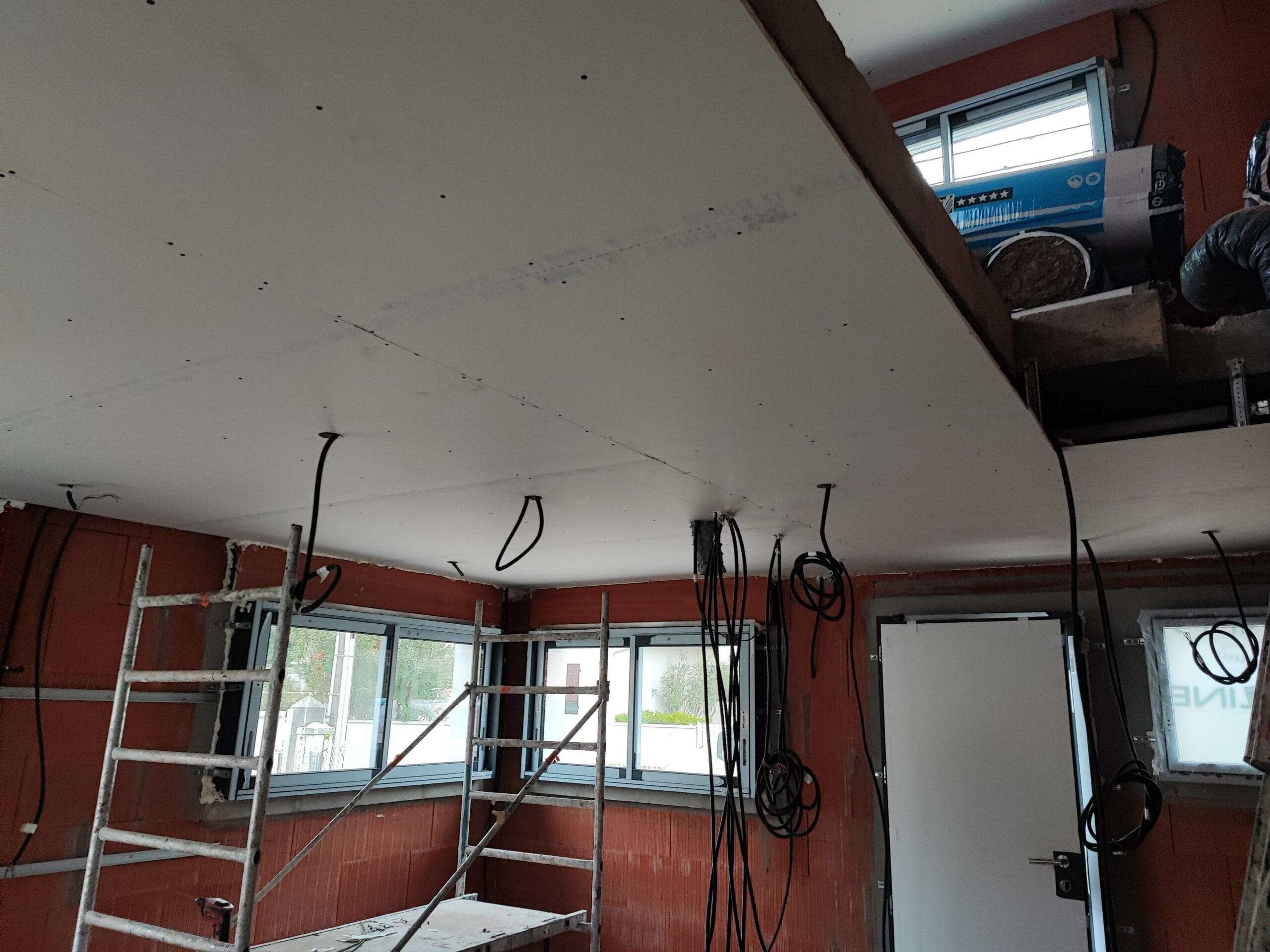 Pose de faux plafond en plaques de plâtre et passage des gaines électriques sur un chantier de rénovation à Capbreton par Landes Habitat